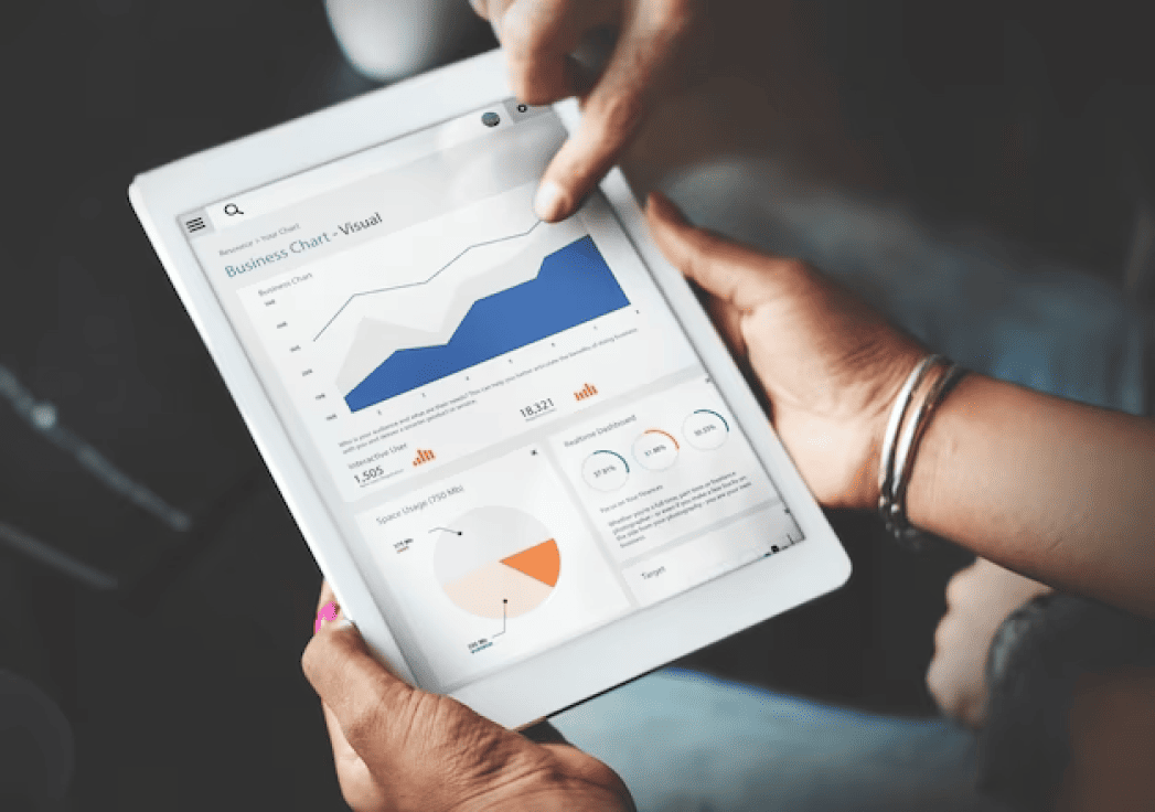 Hands-using-tablet-screen-showing-statistics-business-data